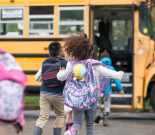 little girl running onto yellow school bus