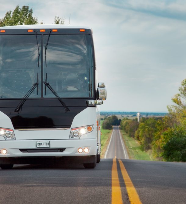 White coach bus parked oh road in farmland