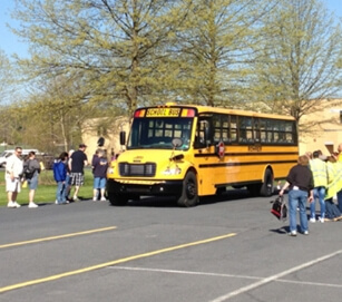Students and parents waiting in parking lot to get onto bus