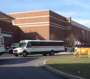 White bus parked in front of large event space