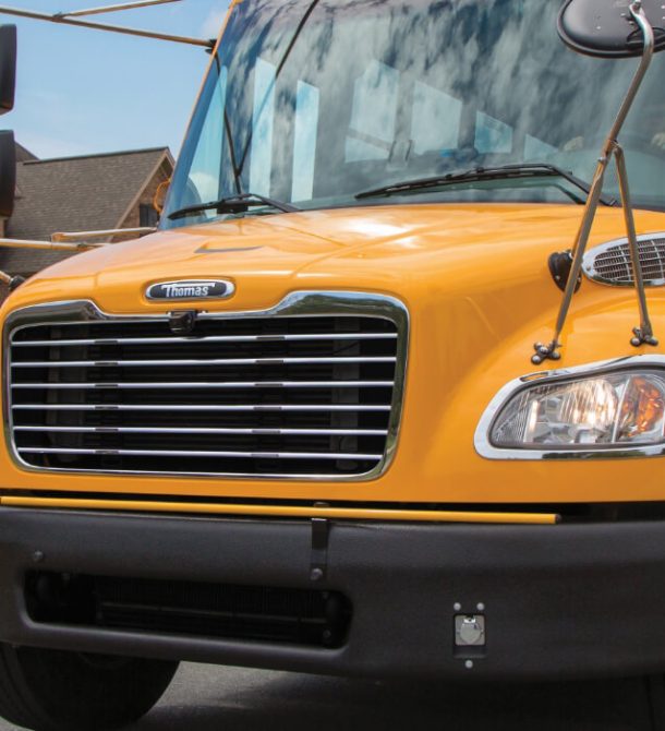 Yellow school bus driving through neighborhood