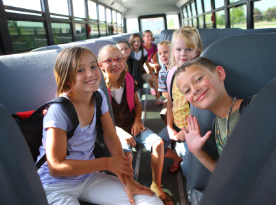 Group of small children smiling on school bus