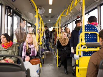 Inside of airport shuttle bus with people sitting and standing