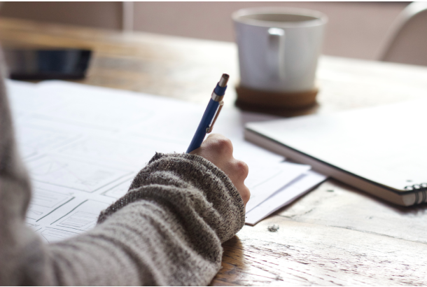 woman writing at coffee shop