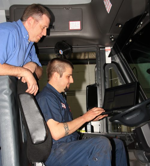 Technician working on bus inside in driver's seat