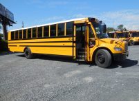 Yellow school bus with open doors in parking lot