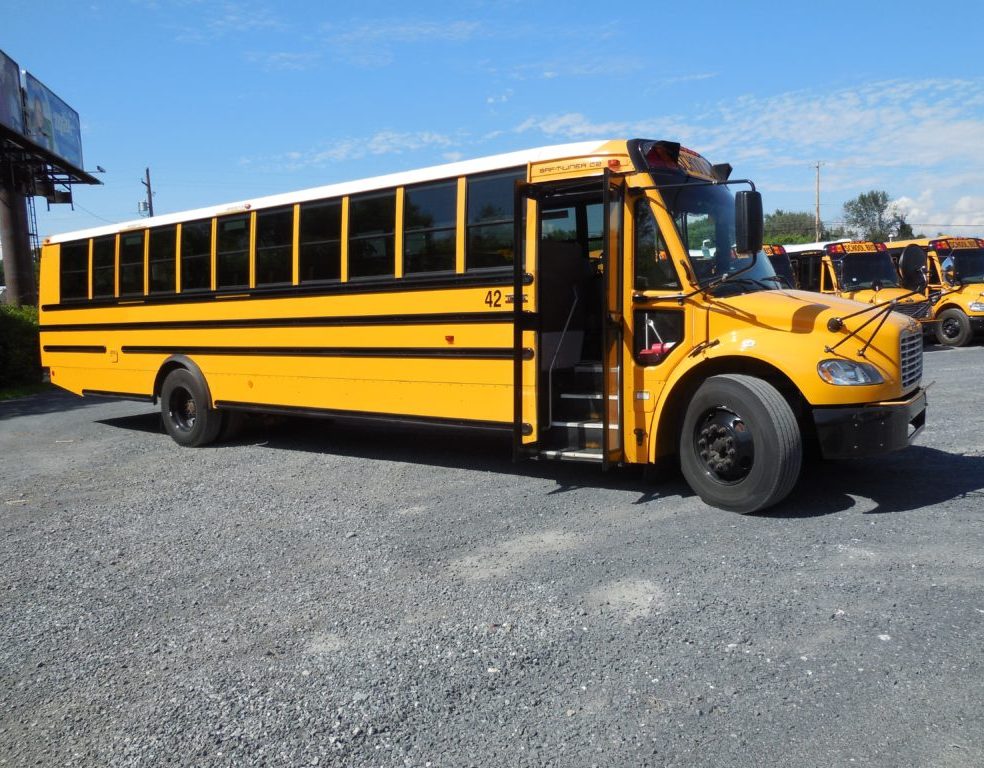 Yellow school bus with open doors in parking lot