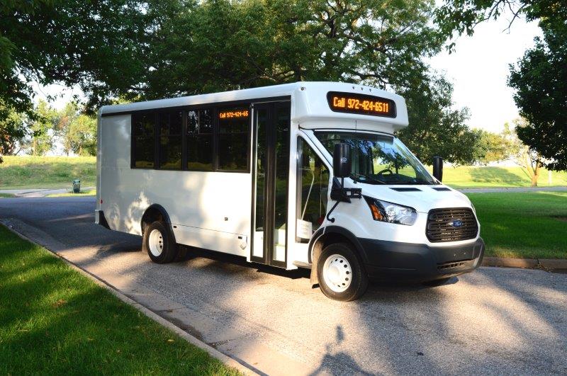 white bus driving down road